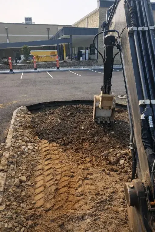 Excavator working inside an established paved property