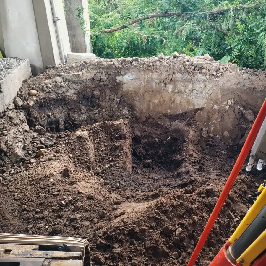 Excavation preparing a building area beside an existing foundation